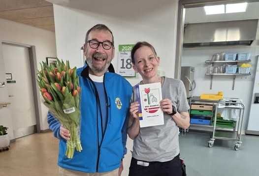 Her er det Jens Erik Bonné fra Lions i Hirtshals, der har leveret en buket tulipaner til Janne Bandholm, som er medarbejder på Eldrecenter Vikingbanke. Foto: Privat.