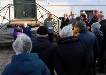 Formidlingschef Jens-Christian Hansen fra Vendsyssel Historiske Museum ses her med en lyttende skare foran Det Gamle Rådhus i Hjørring. Foto: VHM.