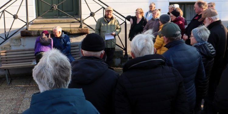 Formidlingschef Jens-Christian Hansen fra Vendsyssel Historiske Museum ses her med en lyttende skare foran Det Gamle Rådhus i Hjørring. Foto: VHM.