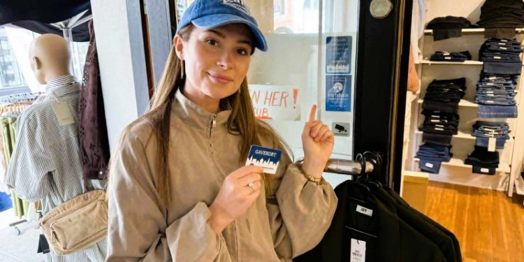 Cecilie Kjeldgård Petersen med gavekortet i hånden, viser de to mærkater, der viser, at her hos Havkyst kan gavekortet bruges, fordi butikken er medlem af HHE. Foto: Niels Skipper.