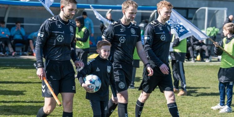 Malthe flankeret af dommertrioen på Nord Energi Arena. Foto: Vendsyssel FF.