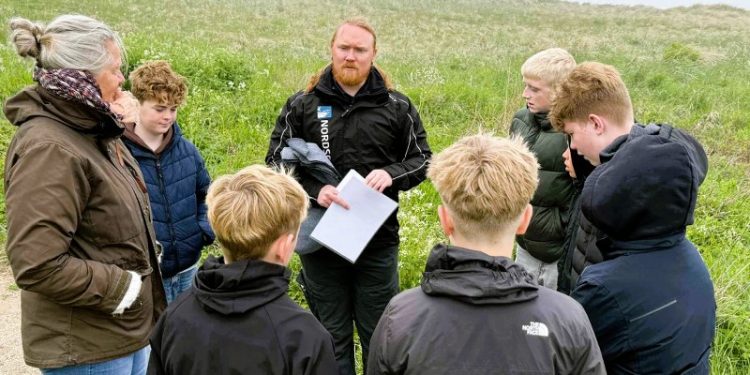 Kim fra Skoletjenesten ved Nordsøen Oceanarium i præsenterer en gruppe elever for en opgave i området nedenfor Hirtshals Fyr. Foto: Niels Skipper.