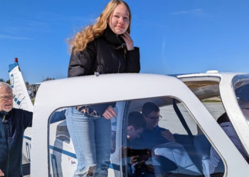 Maja Rosendal er på vej ind i Karsten Moses lille sportsfly hjulpet af Knud Andersen fra Sindal Flyveklub. Foto: Niels Helver.