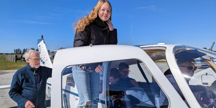 Maja Rosendal er på vej ind i Karsten Moses lille sportsfly hjulpet af Knud Andersen fra Sindal Flyveklub. Foto: Niels Helver.