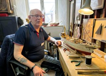 Knud Mogensen fra Hirtshals ved den endnu ikke helt færdige model af Skoleskibet Danmark  arbejdsbordet i Håndværkernes Hus. Foto: Niels Skipper.