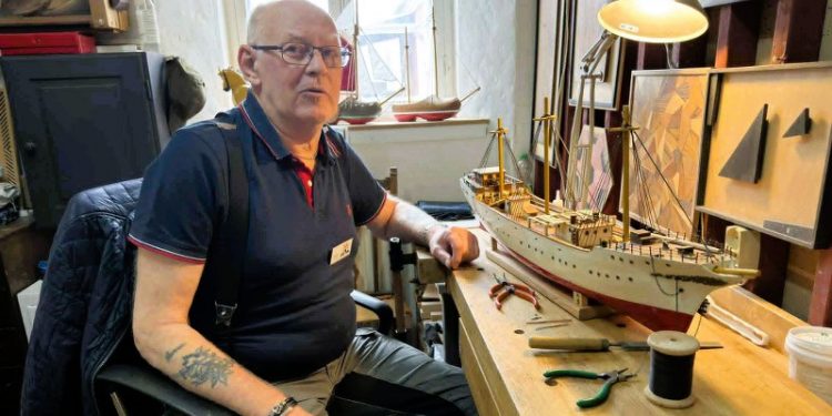 Knud Mogensen fra Hirtshals ved den endnu ikke helt færdige model af Skoleskibet Danmark arbejdsbordet i Håndværkernes Hus. Foto: Niels Skipper.