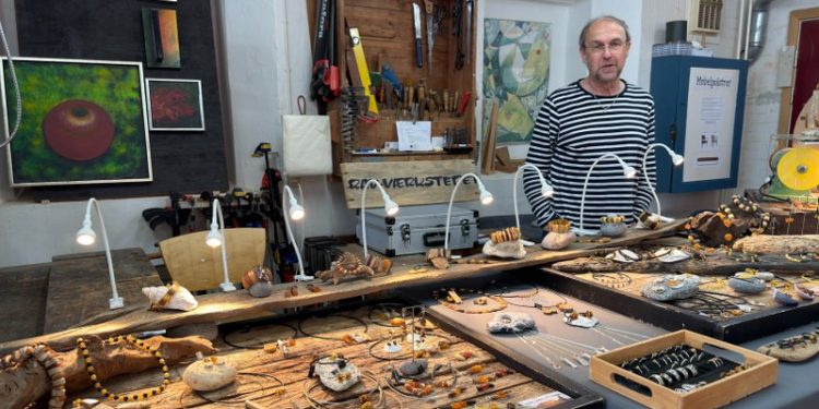 Kunsthåndværker Andreas Wörner ved Rav-Værkstedets stand med de smukke smykker i Håndværkernes Hus. Foto: Niels Skipper.