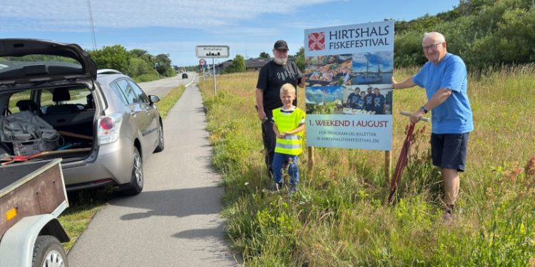 Handelschef Per Martensen i gang med opsætning af infoskilte om Hirtshals Fiskefestival. Handelschefen får kompetent hjælp af Ole Olesen og barnebarnet Jens. Foto: Niels Skipper.
